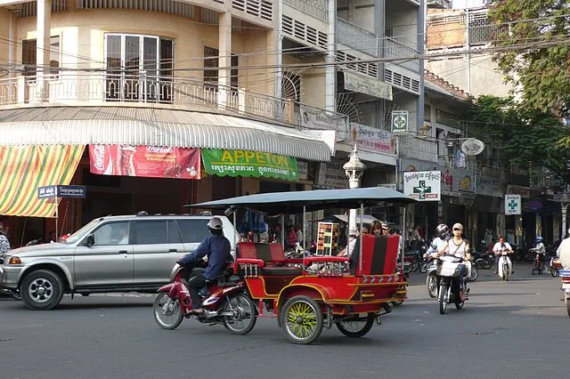 Cambodia tuk tuk 4 wheels Cambodia tuk tuk with motorcycle Photo by: ajai [CC BY 2.0 (https://creativecommons.org/licenses/by/2.0)]